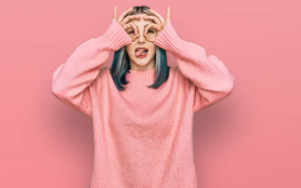 분홍색 양모의 스웨터 현대의 소녀는 쌍안경 내밀고 손가락을 통하여 응시하는 — 스톡 사진