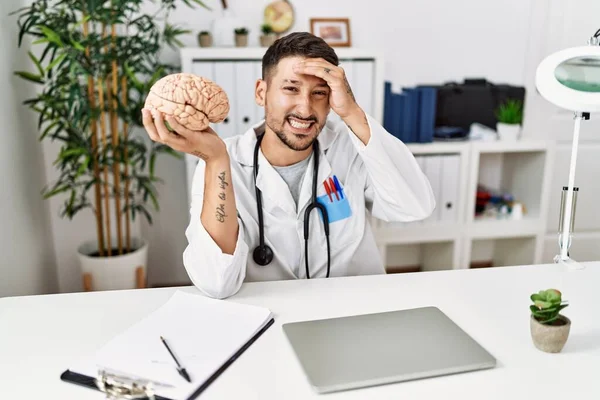 Joven Médico Sosteniendo Cerebro Clínica Médica Estresado Frustrado Con Mano — Foto de Stock