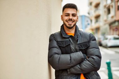 Yakışıklı, sakallı, neşeli ve kendine güvenen, kışlık palto giyen bir İspanyol.