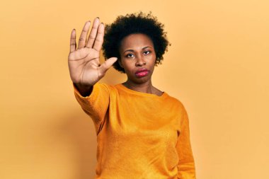 Gündelik kıyafetler giyen genç Afro-Amerikan kadın avucunun içi gibi şarkı söylemeyi kesiyor. Yüzünde olumsuz ve ciddi bir jest olan uyarı ifadesi. 