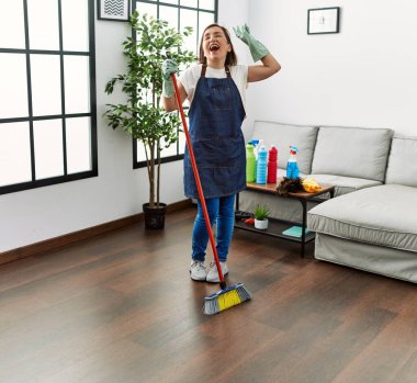 Orta yaşlı İspanyol kadın evde hizmetçi olarak dans ediyor.