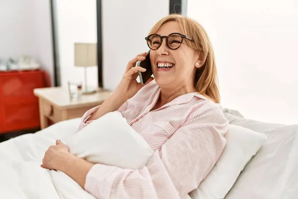 Medelålders Blond Kvinna Talar Smartphone Liggande Sängen Hemma — Stockfoto
