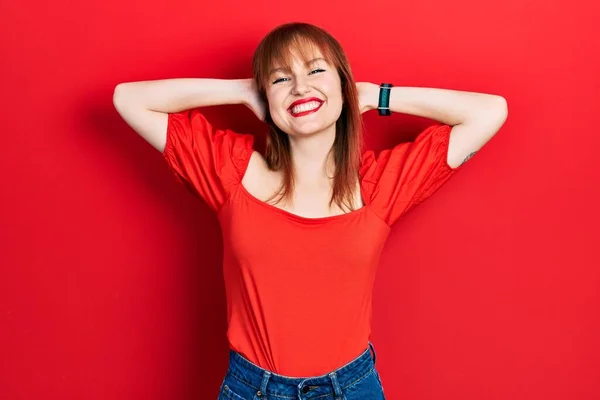 红头发的年轻女子穿着宽松的红色T恤 手挽手 头和脖子后面都挂着幸福的笑容 — 图库照片