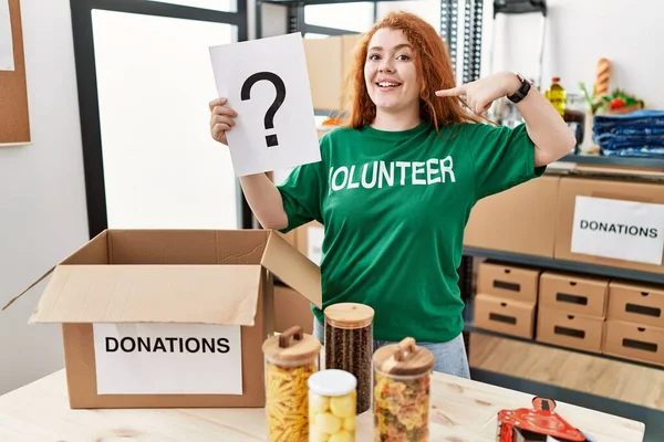 Young Redhead Woman Wearing Volunteer Shirt Holding Question Mark Pointing — Stock Photo, Image