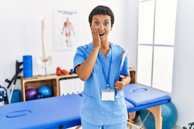 Kısa saçlı, İspanyol bir kadın. Ağrı kesici kliniğinde çalışıyor. Korkuyor ve şoka uğruyor. 