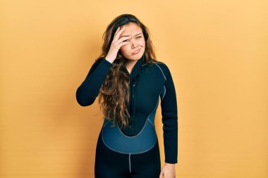 Genç İspanyol kız dalgıç neoprene üniforması giyiyor. Alnındaki bir sorun yüzünden endişeli ve stresli. Kriz için endişeli. 