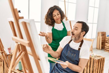 Sanat okulunda resim yapan orta yaşlı bir öğrenci ve öğretmen..