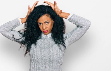 Orta yaşlı Afro-Amerikalı kadın günlük kıyafetler giyip tavşan kulağı hareketi yapıyor. Avuçlarıyla alaycı ve şüpheci görünüyor. Paskalya tavşanı konsepti. 