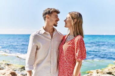 Genç İspanyol çift tatilde gülümsüyor kumsalda mutlu kucaklaşmalar