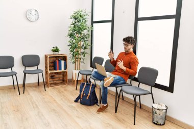 Genç İspanyol adam gülümsüyor. Bekleme odasında kendine güvenen bir video var.