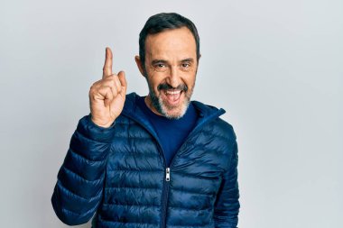 Gündelik kıyafetler giyen orta yaşlı İspanyol bir adam başarılı bir fikri işaret ediyor. Heyecanlı ve mutlu. Bir numara.. 