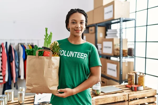 Young African American Woman Wearing Volunteer Uniform Holding Groceries Paper — Stock Photo, Image