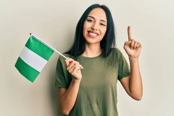 Young Hispanic Girl Holding Nigeria Flag Smiling Idea Question Pointing — Stock Photo, Image