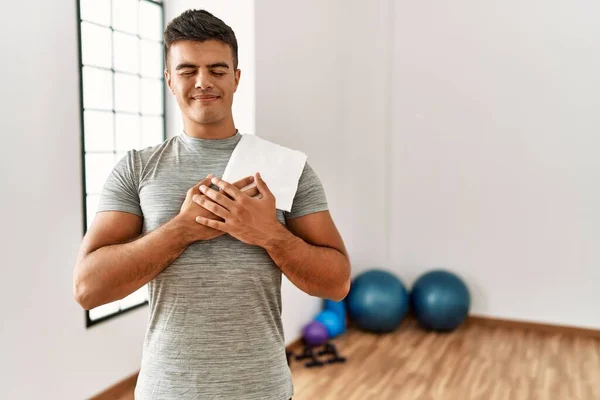 Young Hispanic Man Wearing Sportswear Towel Gym Smiling Hands Chest — Fotografia de Stock