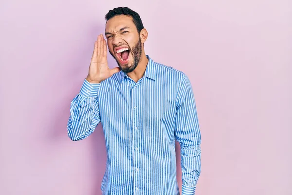 髭を生やしたヒスパニック系の男性は カジュアルな青いシャツを叫んで大声で口の上に手で横に叫んでいる コミュニケーションの概念 — ストック写真