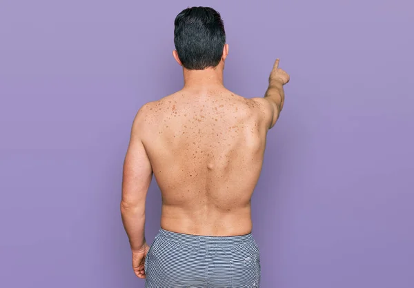 Handsome Young Man Wearing Swimwear Shirtless Posing Backwards Pointing Ahead — Foto Stock