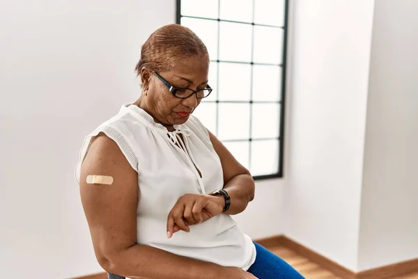 Starší Hispánská Žena Dostat Vakcínu Ukazující Ruku Náplastí Kontrolu Času — Stock fotografie