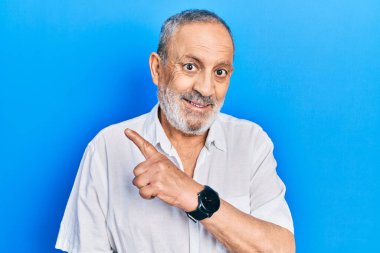 Yakışıklı, son sınıf öğrencisi, sakallı, sıradan, beyaz tişörtlü, neşeli, gülümseyen, elleri ve parmaklarıyla yüzünü gösteren mutlu ve doğal bir ifadeyle. 