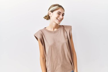 Genç sarışın kadın izole edilmiş arka planda duruyor. Seksi bir ifadeyle kameraya bakıyor. Neşeli ve mutlu bir yüzü var.. 