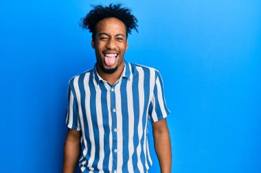 Sakallı, sıradan çizgili gömlek giyen, dilini komik bir ifadeyle dışarı çıkaran Afrikalı genç bir Amerikalı. duygu kavramı. 