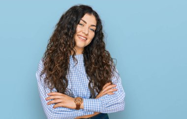 Gündelik kıyafetler giyen, kollarını kavuşturup kameraya gülümseyen genç İspanyol kız. pozitif kişi. 