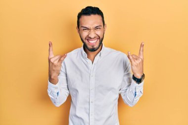 Sakallı, iş gömleği giyen, çılgın bir ifadeyle bağıran, elleri havada rock sembolü yapan İspanyol bir adam. Müzik yıldızı. ağır kavram. 