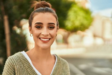 Güzel esmer kadın güler yüzlü mutlu ve kendinden emin sonbaharın güneşli bir gününde şehirde.