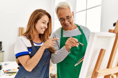 Orta yaşlı resim öğretmeni ve resim stüdyosunda gülümseyen mutlu bir öğrenci..