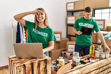Bağışta gönüllü tişört giyen genç kadın ve adam gülümsüyor ve gülümsüyor. 