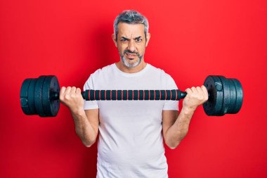 Yakışıklı, orta yaşlı, gri saçlı spor giyimli, haltersiz ve kafası karışık bir adam. şüphe kavramı. 