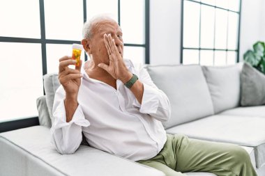 Kıdemli adam elinde haplarla el ele tutuşuyor gizli söylentiler yayıyor, kötü niyetli konuşmalar fısıldıyor. 