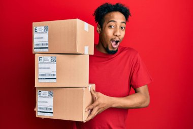 Elinde sakallı, çılgın kutlama paketleri olan genç Afro-Amerikalı bir adam. Başarı için hayrete düşmüş ve gözleri açık, heyecanlı bir şekilde bağırıyor.. 