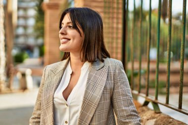 Genç İspanyol iş kadını şehirde mutlu mesut ayakta duruyor..