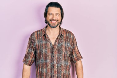 Orta yaşlı beyaz bir adam günlük kıyafetler giyiyor ve yüzünde mutlu ve havalı bir gülümseme var. şanslı kişi. 