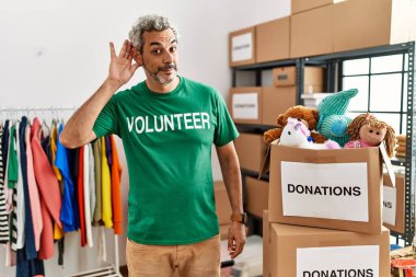 Bağışta gönüllü tişört giyen orta yaşlı İspanyol adam dedikodu ya da dedikodulara kulak misafiri oluyor. Sağırlık kavramı. 