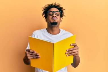 Sakallı, gözlüklü, komik yüzlü, yanakları şişen bir kitap okuyan Afrikalı genç bir Amerikalı. Ağzı havayla şişer, havayı yakalar.. 