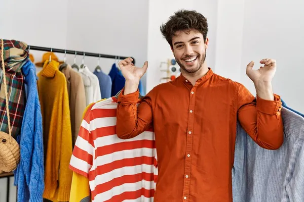 Ung Latinamerikansk Kund Man Ler Glad Hålla Kläder Klädaffär — Stockfoto