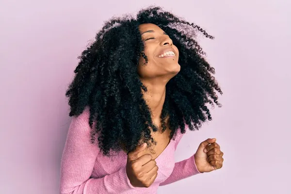 Африканская Американка Афроволосами Розовой Рубашке Взволнованная Успехом Поднятыми Руками Закрытыми — стоковое фото
