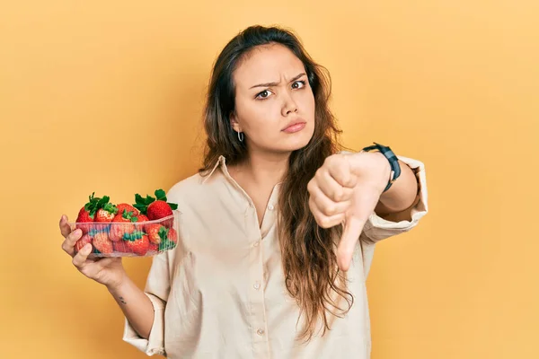 Young Hispanic Girl Holding Strawberries Looking Unhappy Angry Showing Rejection — Stock Photo, Image