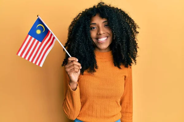 Африканская Американка Афроволосами Держащая Флаг Малайзии Выглядит Позитивно Счастливо Стоя — стоковое фото
