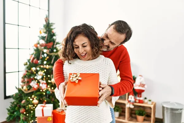 Középkorú Spanyol Pár Mosolyog Boldog Gazdaság Karácsonyi Ajándék Otthon — Stock Fotó