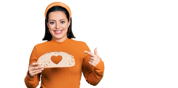 Νέοι Ισπανόφωνοι Κορίτσι Κρατώντας Καρβέλι Ψωμί Σχήμα Καρδιάς Χαμογελώντας Χαρούμενος — Φωτογραφία Αρχείου