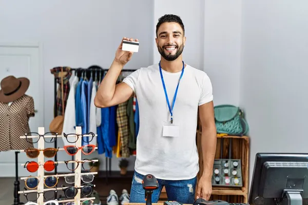 持有服装店信用卡的年轻Arab男子店主 — 图库照片