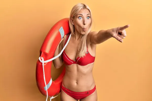 Young Blonde Woman Wearing Bikini Holding Lifeguard Float Pointing Finger — Stock Photo, Image