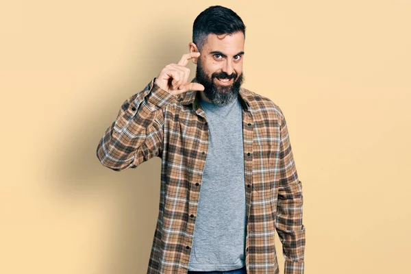 髭を生やしたヒスパニック系の男性は カジュアルなシャツを着て笑顔と指を見て カメラと小さなサイズの看板を行う手で自信を持ってジェスチャー 概念を測定し — ストック写真