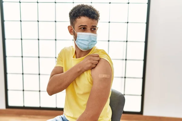 若いですArab男身に着けています医療マスクとともにバンド援助のために腕の上でCovid 10ワクチン接種で病院 — ストック写真