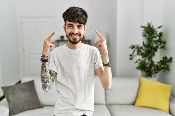 Homem Hispânico Com Barba Sala Estar Casa Sorrindo Apontando Para — Fotografia de Stock
