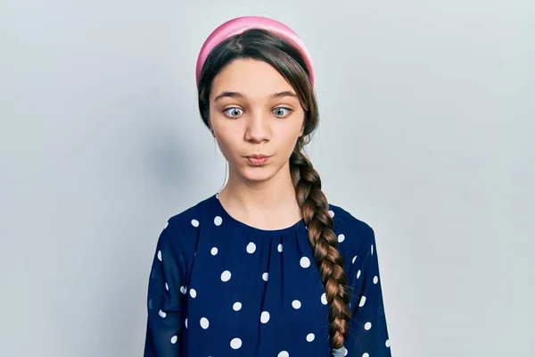 狂気とコミカルなジェスチャーで魚の顔を作るエレガントな外観を身に着けている若いブルネットの女の子 面白い表現 — ストック写真