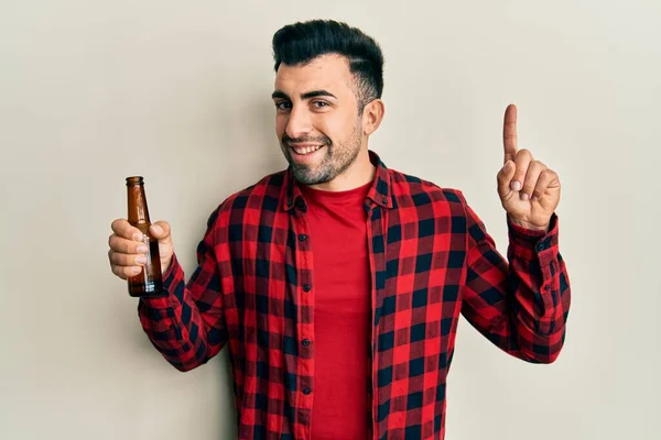 Joven Hispano Bebiendo Una Botella Cerveza Sorprendido Con Una Idea — Foto de Stock