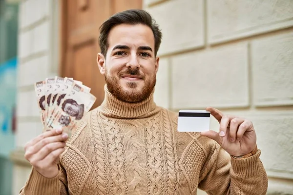 Ung Kaukasisk Mand Med Mexicanske Pesos Sedler Kreditkort Byen - Stock-foto
